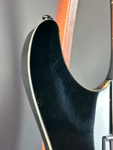 Close-up of a guitar's neck and headstock on a gray background