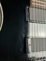 Close-up of a guitar's neck and fretboard with a dark finish.