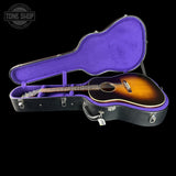 Acoustic guitar in a black and purple case with 'Tone Shop' logo.