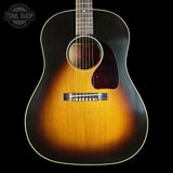 Acoustic guitar with a sunburst finish on a black background, featuring the Tone Shop logo.