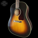 Acoustic guitar with a sunburst finish on a black background, featuring the Tone Shop logo.