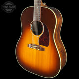 A classic acoustic guitar with a natural sunburst finish, shown from a three-quarters angle against a solid black background. A Tone Shop watermark is visible in the top-left corner.