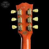 Guitar headstock with tuning pegs on a black background, featuring the Tone Shop logo.