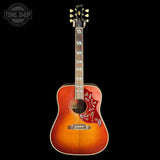 Acoustic guitar with a sunburst finish on a black background, featuring the Tone Shop logo.