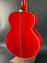 Red acoustic guitar on a dark background