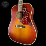 Acoustic guitar with a sunburst finish on a black background, featuring the Tone Shop logo.