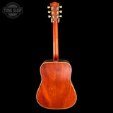 Back view of a wooden acoustic guitar with 'Tone Shop' logo in the corner.