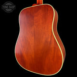 Back view of a wooden acoustic guitar with 'Tone Shop' logo in the corner.