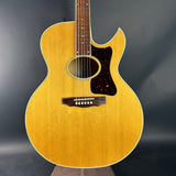 Acoustic guitar with a wooden finish on a dark background