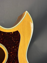 Close-up of a guitar's wooden neck and fretboard on a dark background