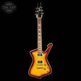 A double-cutaway electric guitar with a sunburst finish, featuring a black headstock and a dark fretboard, shown against a solid black background with a Tone Shop watermark in the top-left corner.