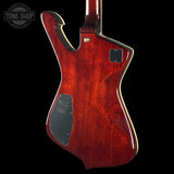 Rear view of an electric guitar with a glossy reddish-brown wood finish, black pickguard, and gold-toned hardware, shown against a black background with a Tone Shop watermark in the top-left corner.