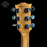 Close-up of the headstock of a Gibson electric guitar, showing six tuning pegs, serial number CS 601337, and the Gibson logo on a black background.