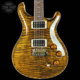 Electric guitar with a wavy wood finish on a black background, featuring the Tone Shop logo.