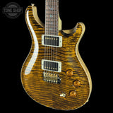 Electric guitar with a wavy wood finish on a black background, featuring the Tone Shop logo.