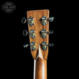 Close-up of a guitar headstock with tuning pegs on a black background, featuring the Tone Shop logo.
