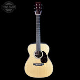 Acoustic guitar with a visible brand logo on a black background