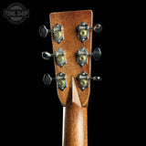 Close-up of the headstock of a guitar, showing six tuning pegs and decorative peg crowns on a dark brown wood neck against a black background. A Tone Shop watermark is visible in the top-left corner.