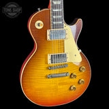 Electric guitar with a sunburst finish on a black background, featuring the Tone Shop logo.
