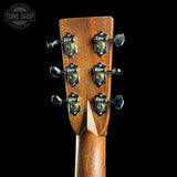 Close-up of a guitar headstock with tuning pegs on a black background, featuring the Tone Shop logo.