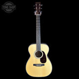 Acoustic guitar with a visible brand logo on a black background