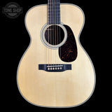 Acoustic guitar with a visible brand logo on a black background