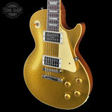 A gold glitter electric guitar with a cream pickguard and brown wood sides, shown against a solid black background. A 'TONE SHOP' watermark is visible in the top-left corner.