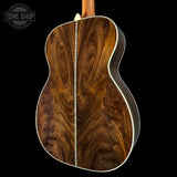 Close-up of a wooden acoustic guitar with a visible brand logo in the corner.