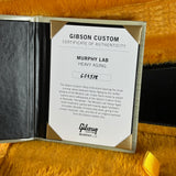 A Gibson Custom Certificate of Authenticity insert for a Murphy Lab Heavy Aging instrument, displayed inside an open black presentation box on a yellow textured background.