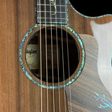 Close-up of a Taylor acoustic guitar's soundhole and wooden body.