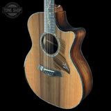 Wooden acoustic guitar with a visible brand logo on a black background