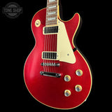 A red glitter electric guitar with a cream pickguard and gold-tone hardware, shown against a solid black background. A 'TONE SHOP' watermark is visible in the top-left corner.