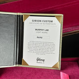 A Gibson Custom Certificate of Authenticity card for a Murphy Lab Light Aging treatment, displayed inside an open gold and black presentation box with deep magenta velvet lining.
