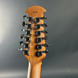Close-up of a guitar headstock with 12 tuning pegs on a gray background