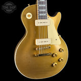 A gold-finished electric guitar with a cream pickguard and gold hardware, shown against a solid black background. A 'TONE SHOP' watermark is visible in the top left corner.
