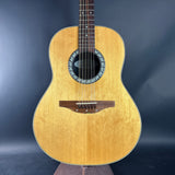 Acoustic guitar with a wooden finish on a dark blue background