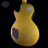 The back of a gold-finished electric guitar, likely a Gibson Les Paul Custom style, shown against a solid black background with a Tone Shop watermark in the top-left corner.