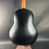Black acoustic guitar body on a gray background