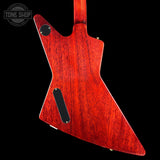 The back of a custom electric guitar with a distinctive angular body, finished in a glossy dark red cherry wood with a prominent black grain pattern, shown against a solid black background.