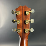 Guitar headstock with tuning pegs on a gray background