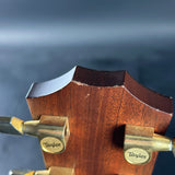Close-up of a Taylor guitar headstock with a blurred blue background