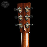 Close-up of a guitar headstock with tuning pegs on a black background, featuring the Tone Shop logo.
