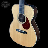 Acoustic guitar with a visible brand logo on a black background