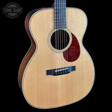 Acoustic guitar with a visible brand logo on a black background