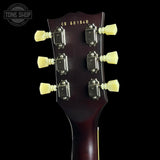 Close-up of a guitar headstock against a black background, showing six light yellow tuning pegs, chrome tuning machines, and gold model text 'CS 601540' on the dark reddish-brown wood backplate. A Tone Shop watermark is visible in the top-left corner.