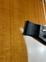 Close-up of a guitar's soundhole with a black pickguard.