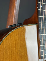 Close-up of a guitar's neck and body on a dark background