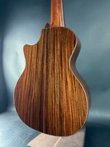 Close-up of a wooden acoustic guitar body on a gray background