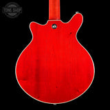 Red electric guitar body on a black background with 'Tone Shop' logo.