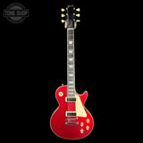 A red Gibson Les Paul Custom electric guitar with a cream pickguard and gold hardware, shown against a solid black background. A 'TONE SHOP' watermark is visible in the top-left corner.